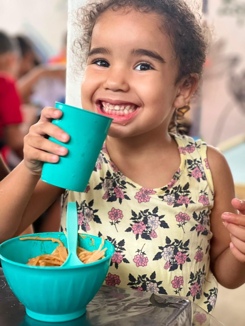 Criança sorrindo com o lanche preparado pelas voluntárias